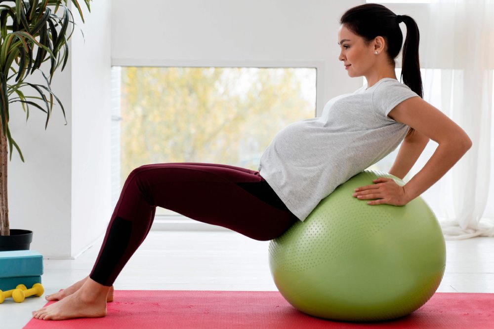 Side View Young Pregnant Woman Exercising Fitness Ball (1)